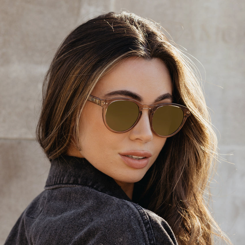 Woman wearing retro round-shaped Tate frame sunglasses with notched keyhole bridge and double rivets detail