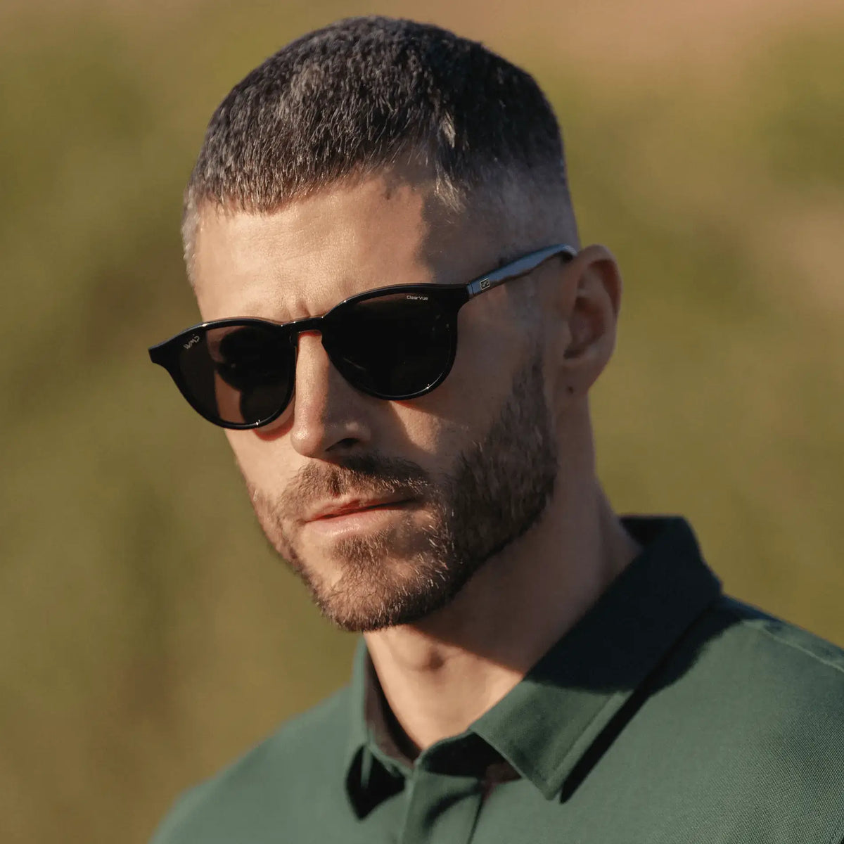 Black / Grey || Round prescription sunglasses with black frame, keyhole bridge, and grey lenses worn by a man outdoors