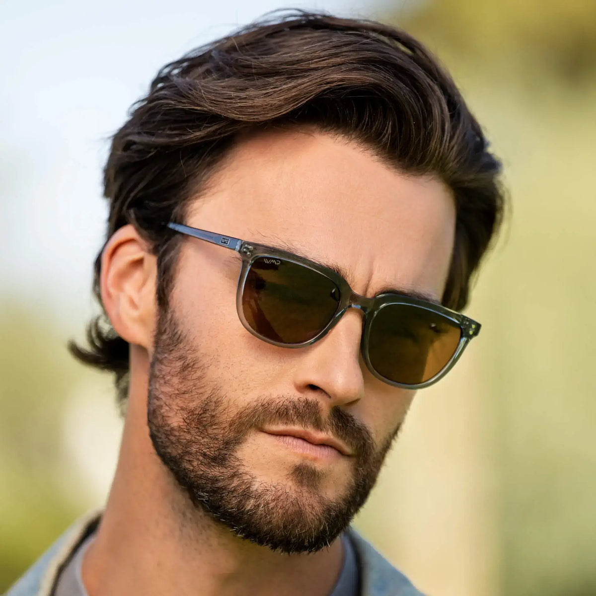 Crystal Stone Blue / Amber || Square prescription sunglasses with crystal stone blue acetate frame and amber lenses worn by a man outdoors