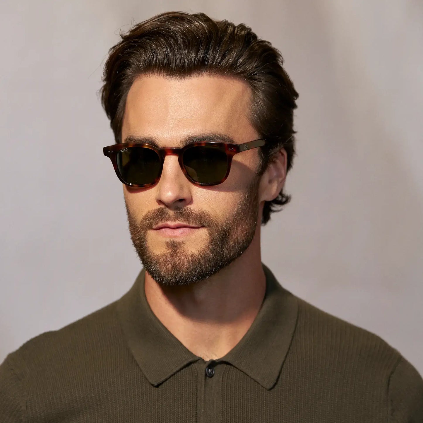 Brown Tortoise / Smoke Green Lens || Man wearing Polarized Sunglasses with a Lightweight Acetate Brown Tortoise Frame and Smoke Green Lenses indoors against a light background