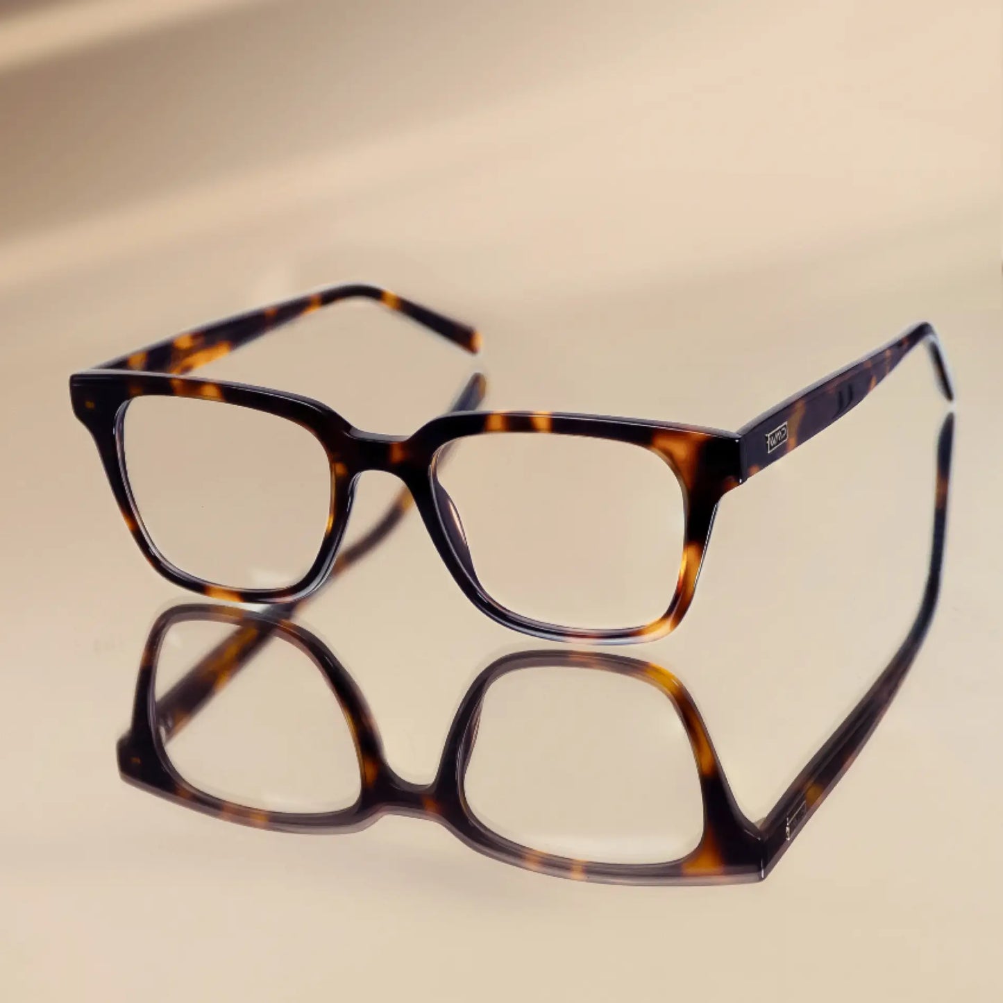 Tortoise Brown || Modern rectangular prescription glasses with tortoise brown frame and integrated bridge resting on reflective surface