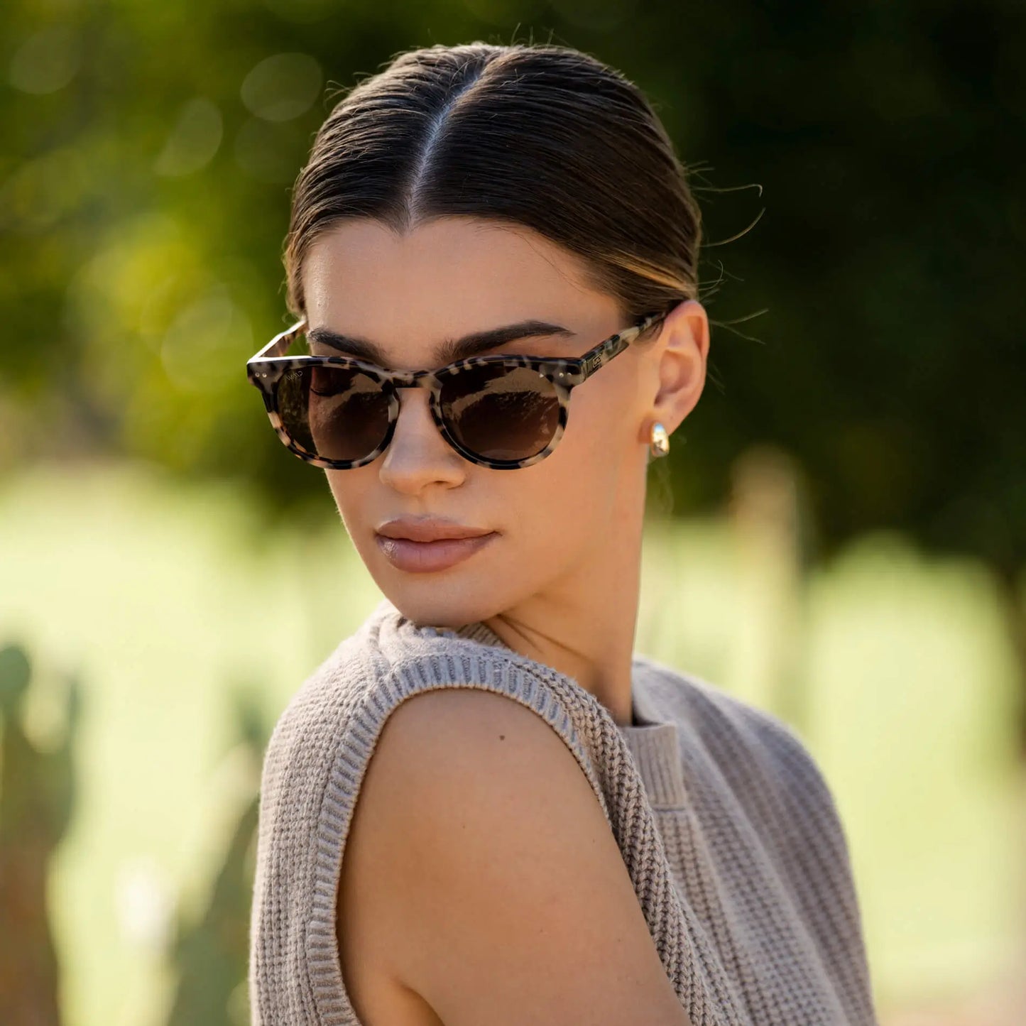 Beige Tortoise / Amber || Woman wearing Tortoise Round Frame Prescription Sunglasses with Brown Lenses outdoors in natural light