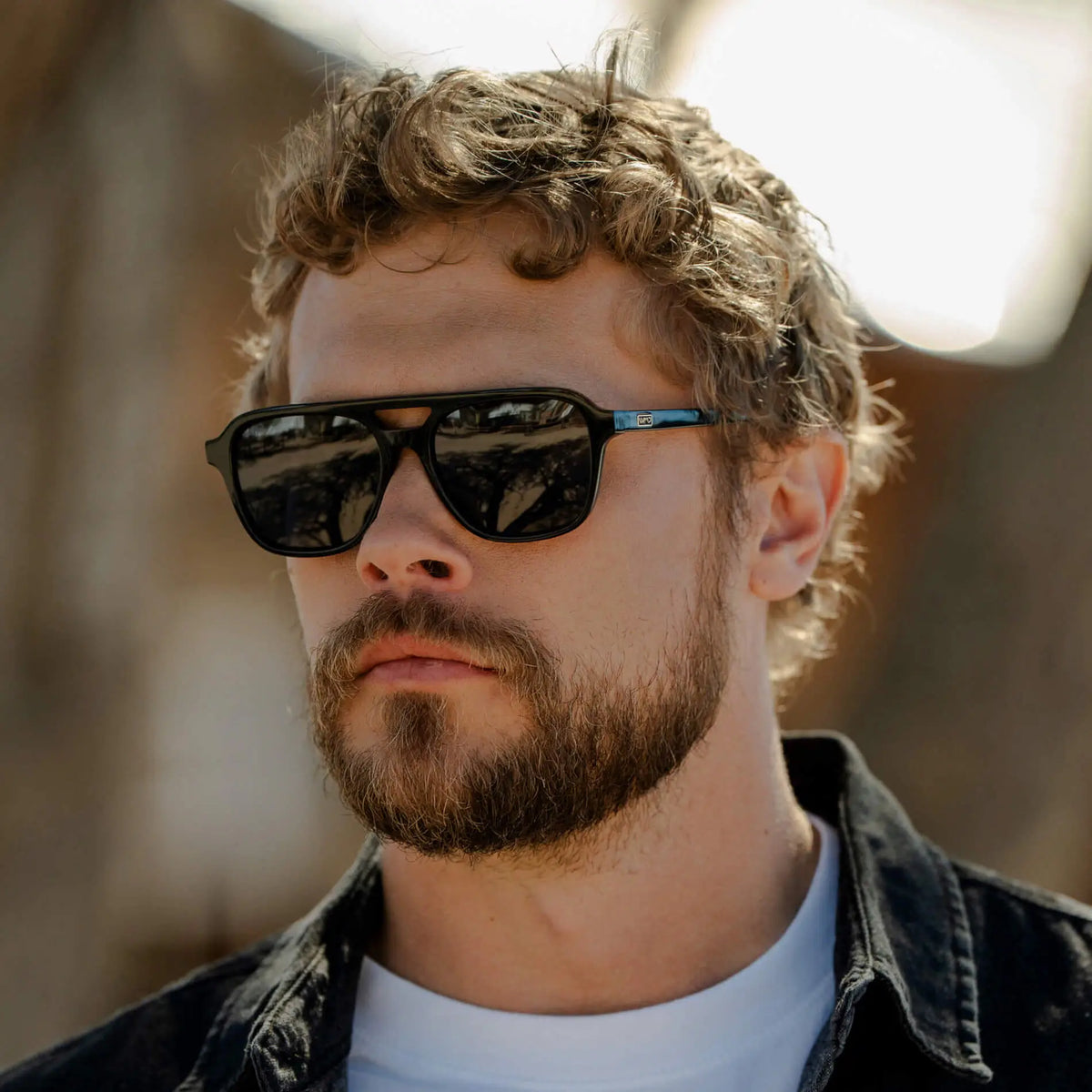 Black / Grey || Square prescription sunglasses with bold acetate frame and double bridge featuring dark lenses worn by man outdoors
