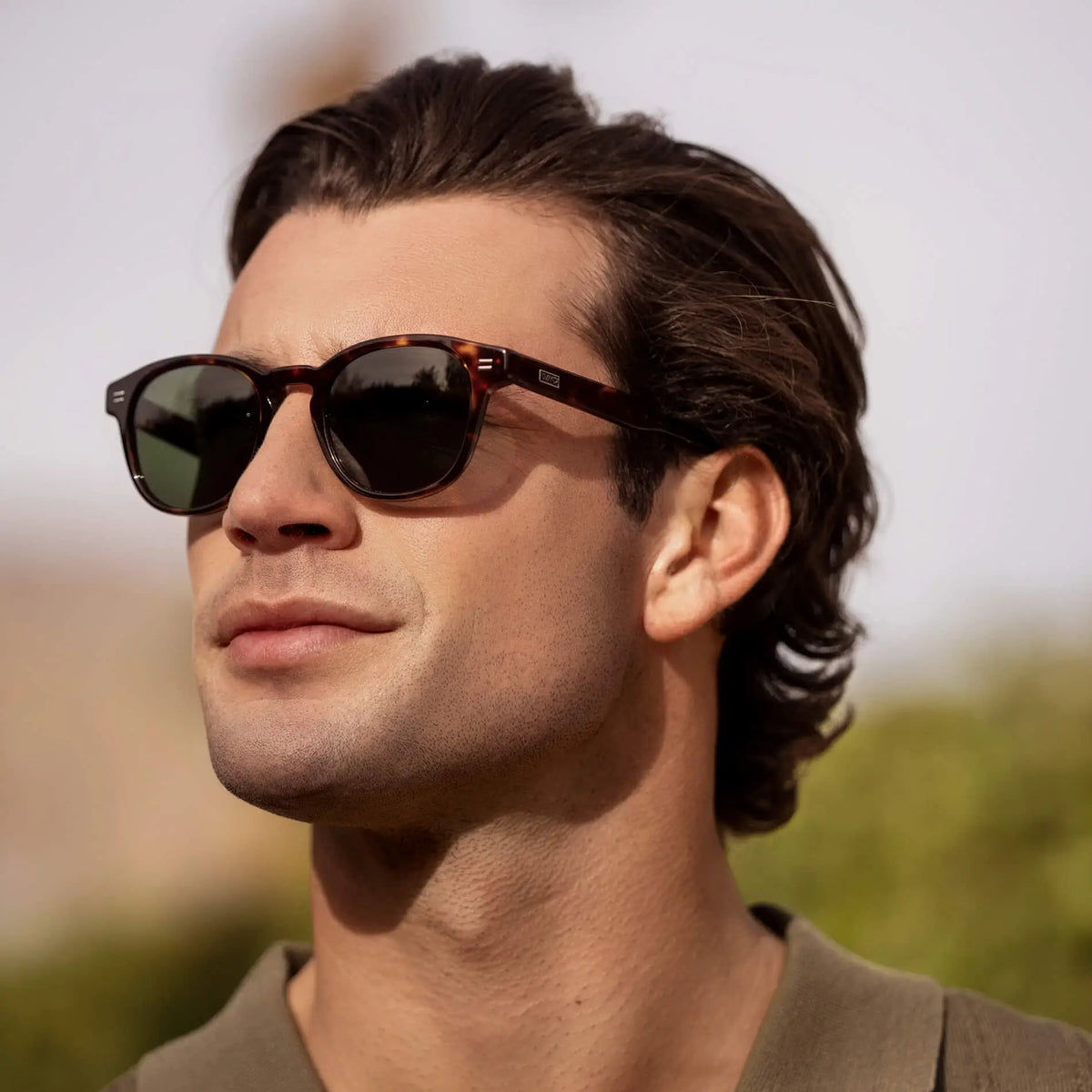 Amber Tortoise / G15 || Model wearing Men's Retro-Inspired Round Prescription Sunglasses with Brown Tortoise Acetate Frame and Green Prescription Lenses