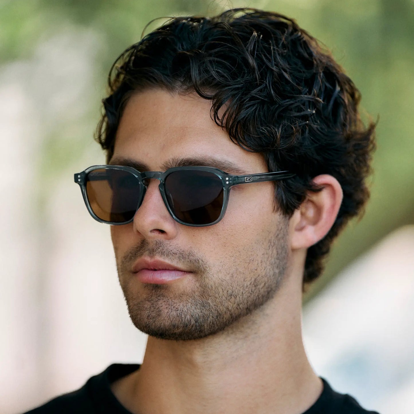 Crystal Stone Blue / Amber || Model wearing Men's Square Prescription Sunglasses with Crystal Blue Frame and Brown Lens
