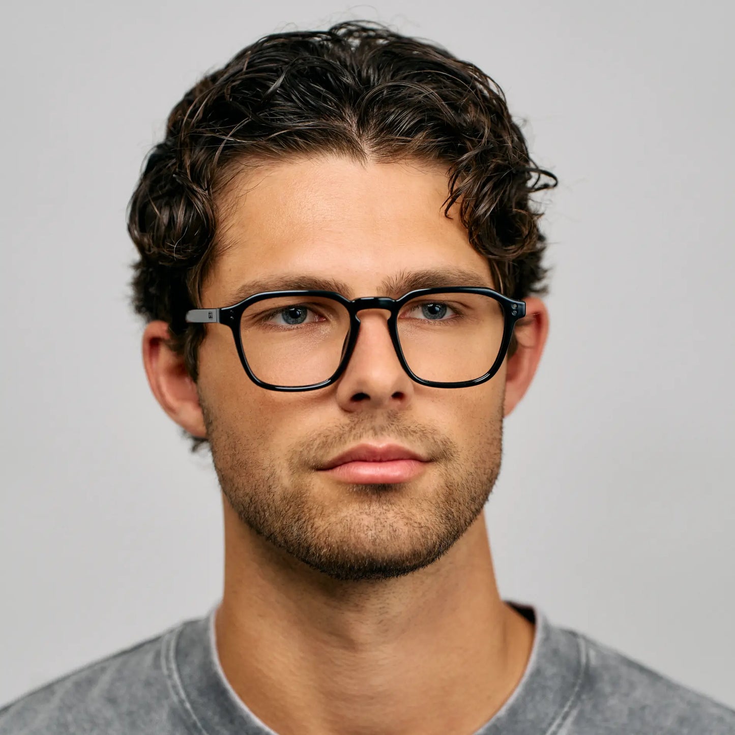 Black || Square prescription glasses with a black frame and clear lenses worn by man indoors