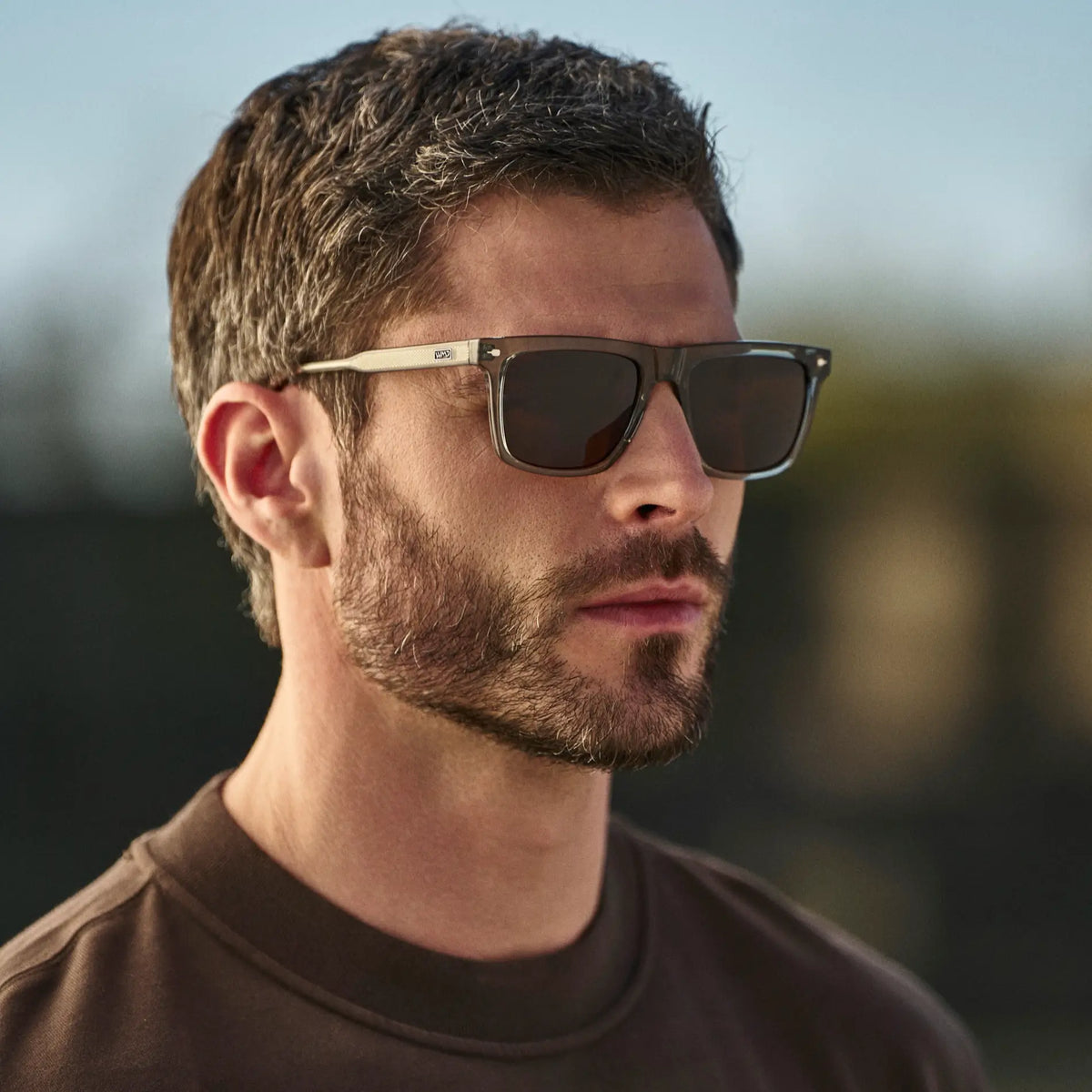Sage Green / Amber || Man wearing Classic Rectangular Prescription Sunglasses with Sage Green Frame and Brown Lens outdoors