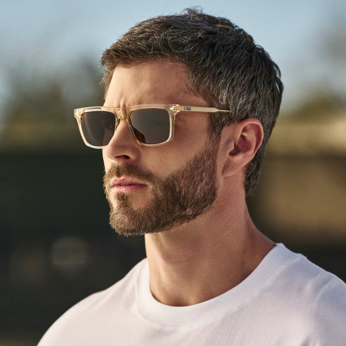 Sand Brown / Amber || Man wearing Classic Rectangular Sunglasses with Sand Brown Frame and Brown Lens outdoors