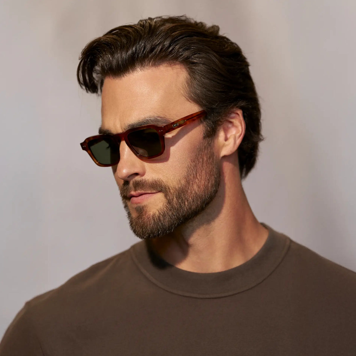 Saddlewood Tortoise / Smoke Green Lens || Side view of man wearing Rectangular Polarized Sunglasses with Saddlewood Tortoise frame and Smoke Green lens against a grey background