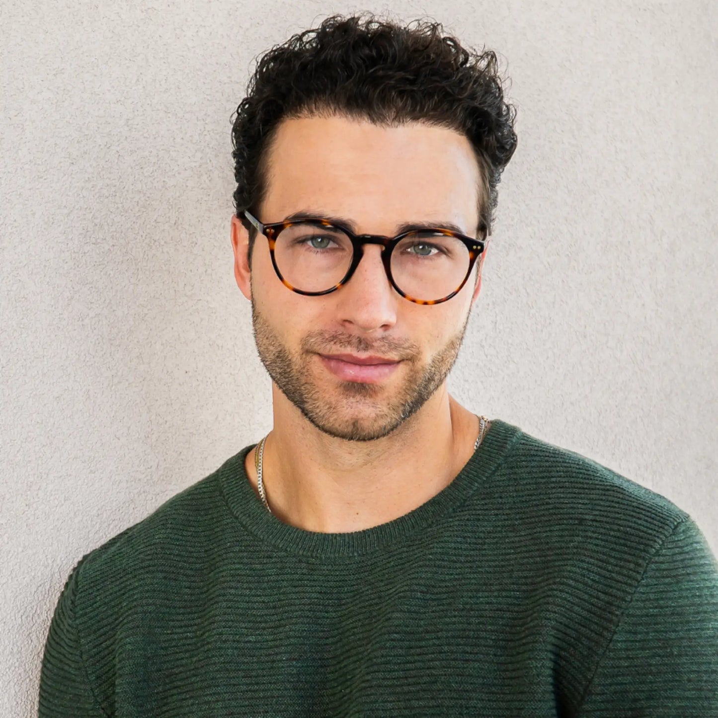 Tortoise Brown || Man with short curly hair wearing tortoise shell rounded glasses with blue light filtering lenses against beige wall