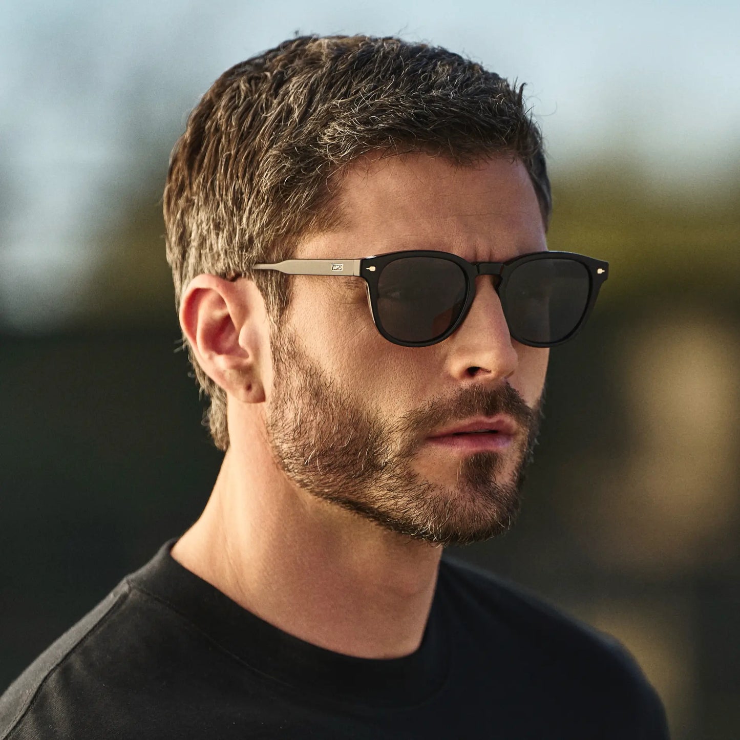 Black / Black Lens || Man wearing Round Sunglasses with Black Frame and Black Oval Lens outdoors