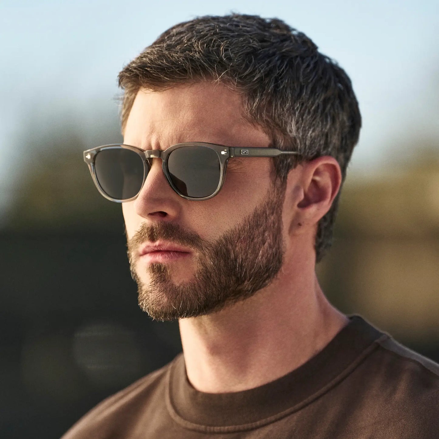Sage Green / Grey || Man wearing Round Prescription Sunglasses with Sage Green Frame and Grey Oval Lens outdoors