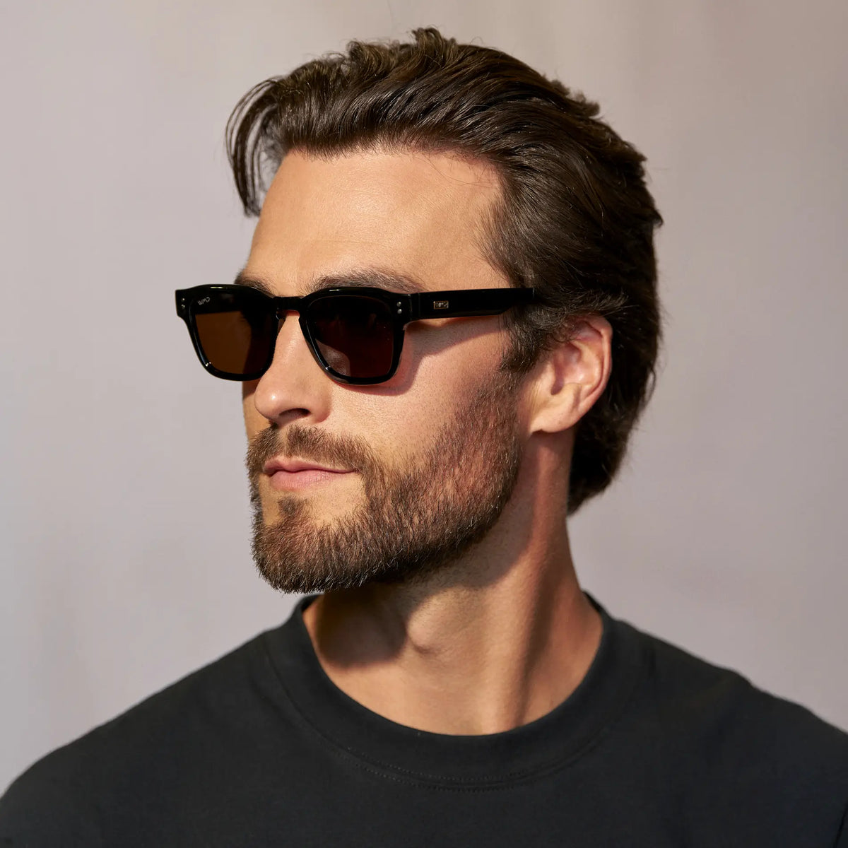 Black / Amber || Model wearing Men's Geometric Rectangular Prescription Sunglasses with Black Acetate Frame and Amber Prescription Lens