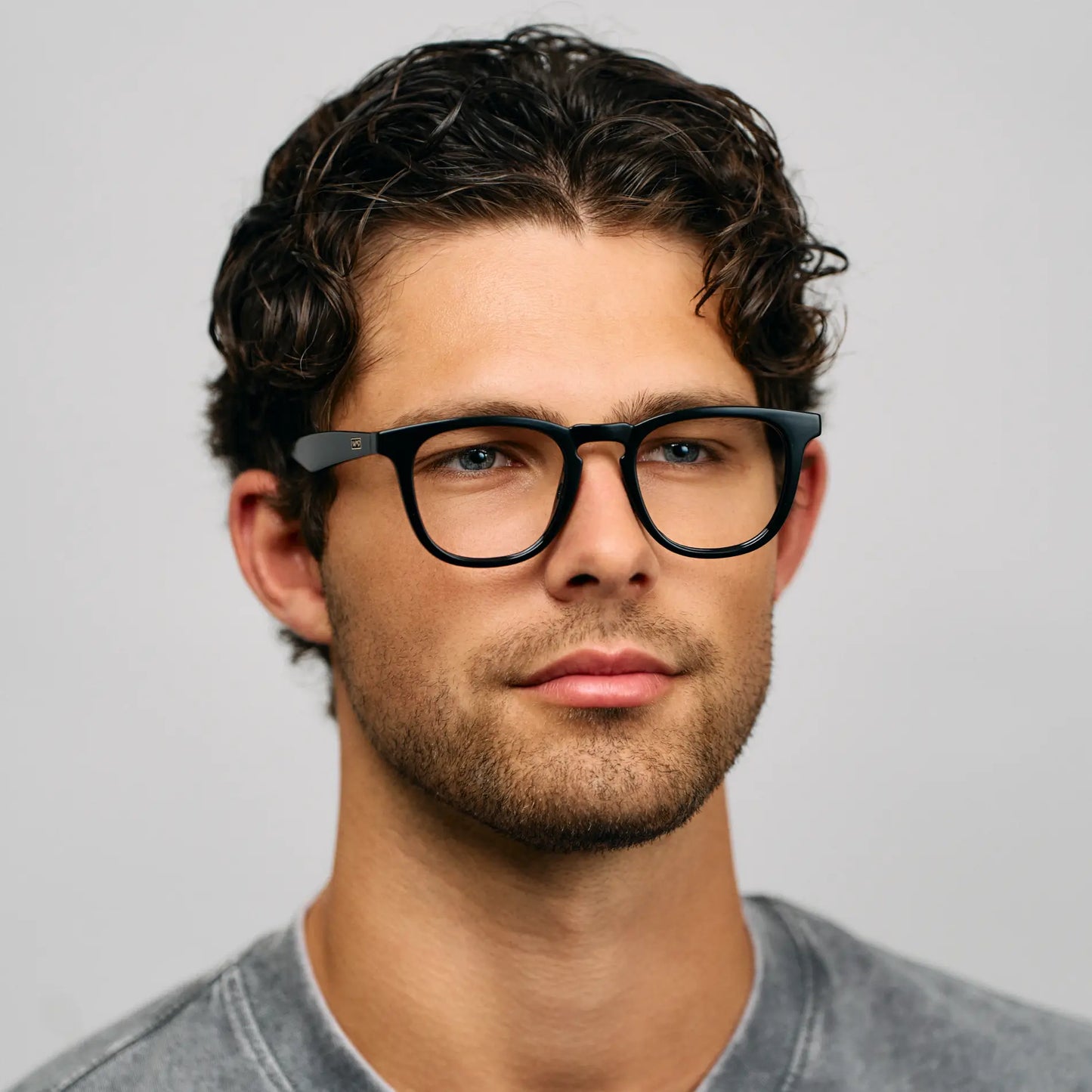 Black || Round prescription glasses with black acetate frame and keyhole bridge worn by man with curly hair indoors