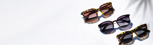 Three pairs of sunglasses displayed on a white surface in natural light