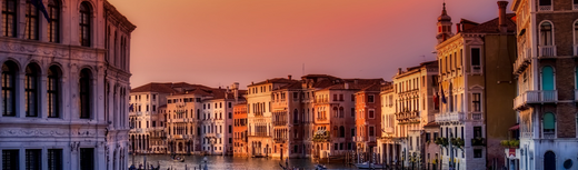 Sunset view of buildings along a canal in Italy with warm evening light
