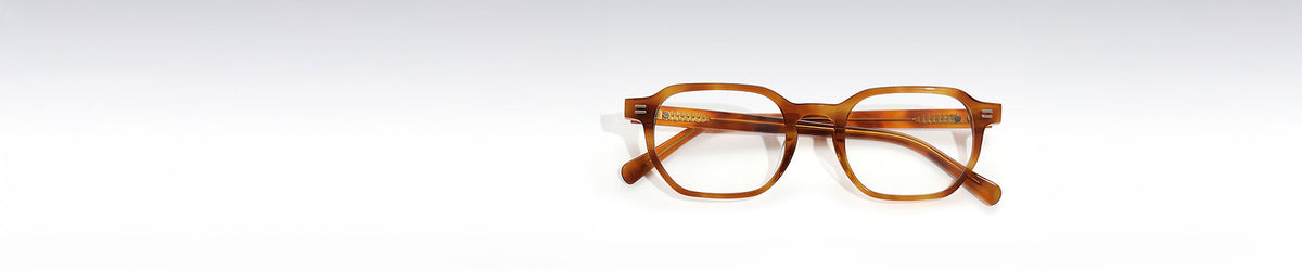 Front-facing view of honey tortoise-colored rectangular eyeglass frames with clear lenses on a white background.