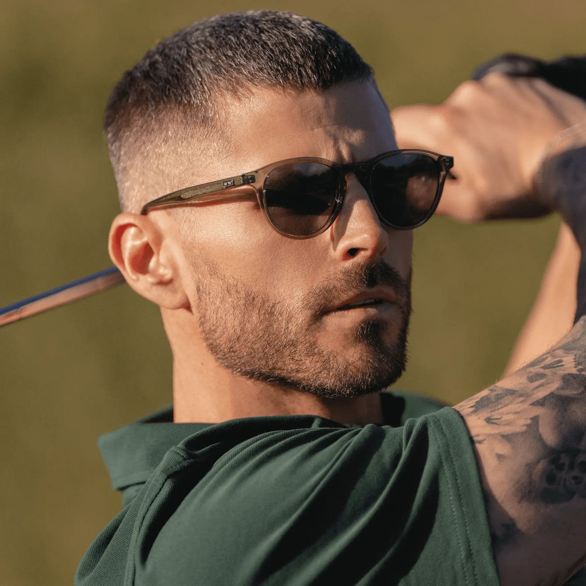 The Greens Kit || Side view of a man wearing Birdie sunglasses in Green outdoors 