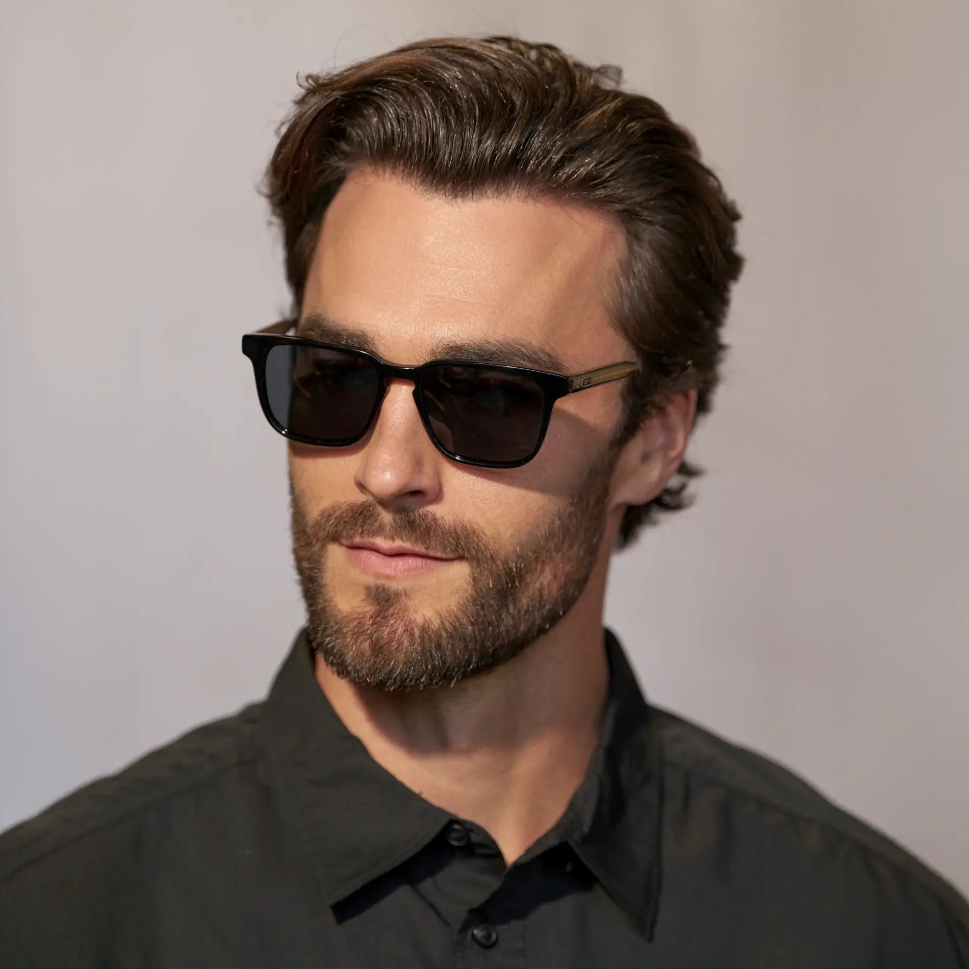 Black / Triple Black Lens || Front view of man wearing Rectangular Polarized Sunglasses with Black Frame and Black Lens against a grey background 