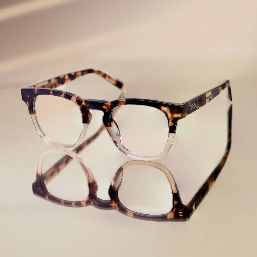 Crystal Brown Tortoise || Aspen tortoise patterned rectangular frames with clear blue light lenses reflected on smooth beige surface