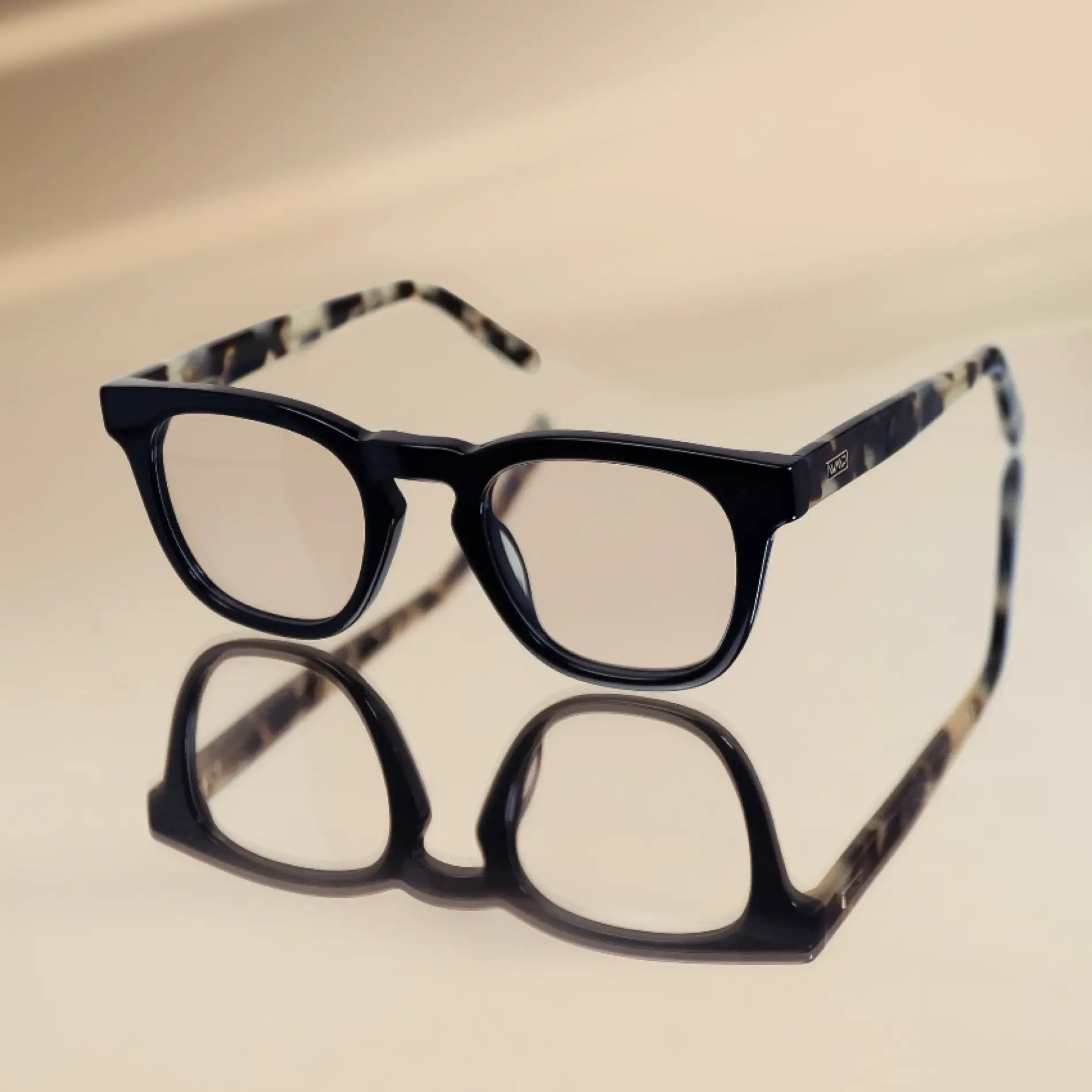 Black Beige Tortoise || Aspen blue light glasses with black front frames and tortoise print temples on reflective surface