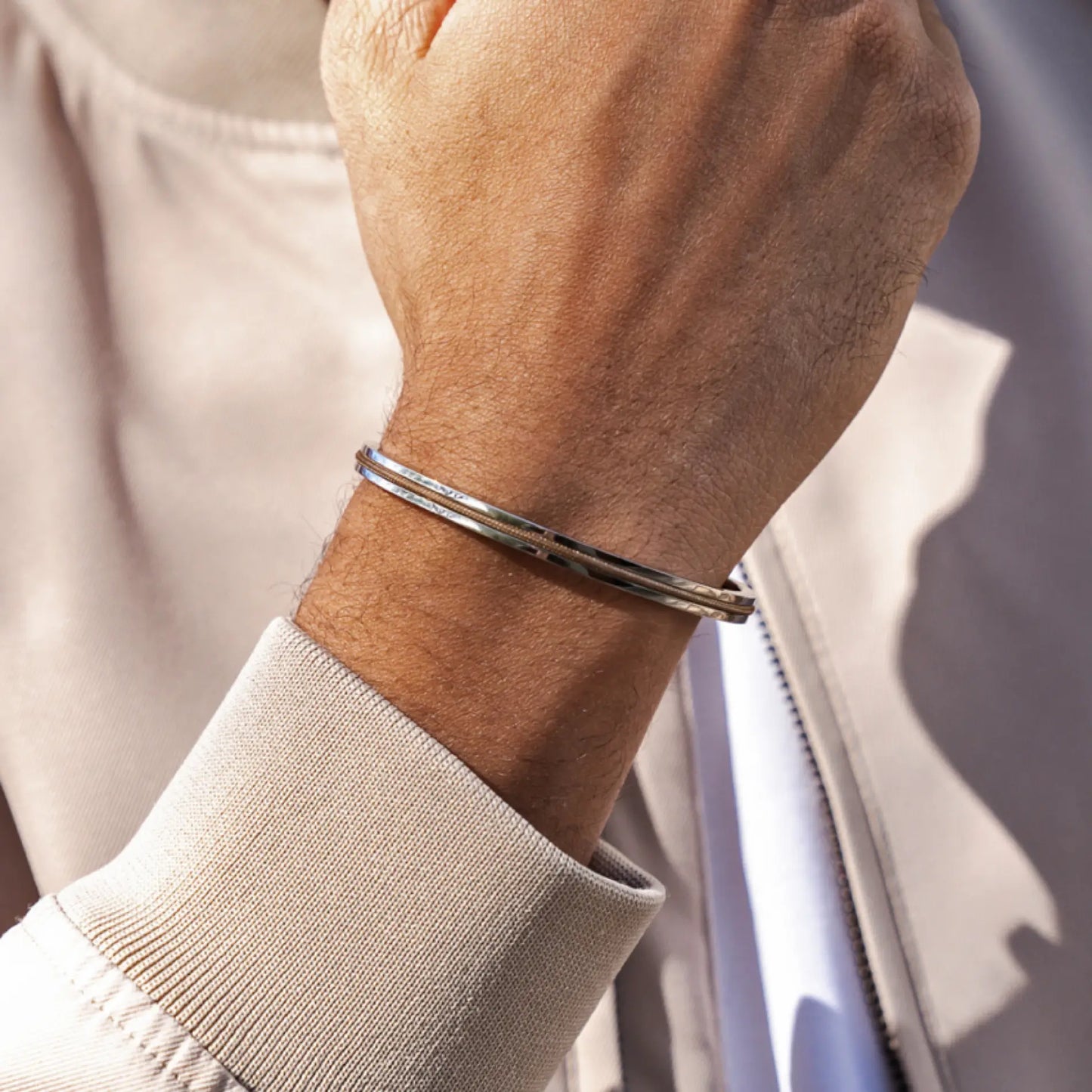 Silver / Desert Tan || Close up of a model wearing the Silver Stainless Steel Adjustable Cuff Bracelet with Tan Nylon Rope in natural lighting. 