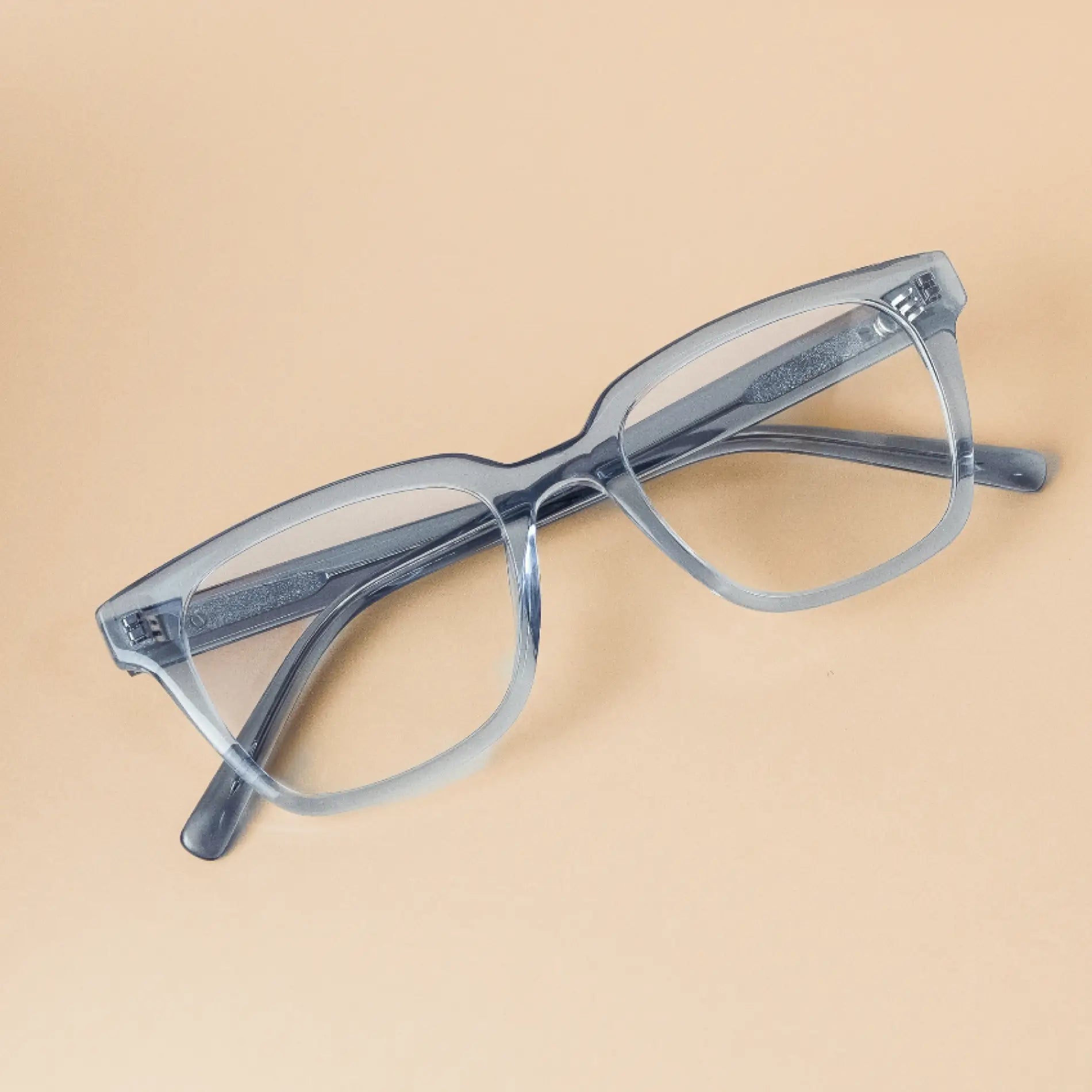 Denim Blue || Carson translucent light blue rectangular frames blue light glasses resting on beige surface