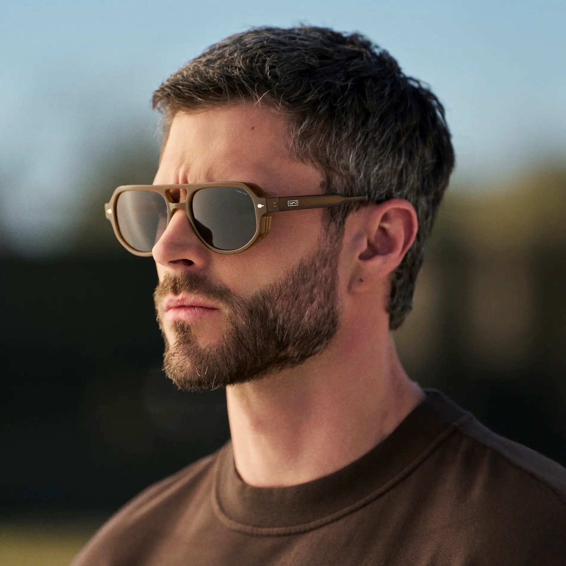 Dune Brown / Black Lens || Man wearing Geometric Aviator Sunglasses with Dune Brown Frame and Black Lens outdoors