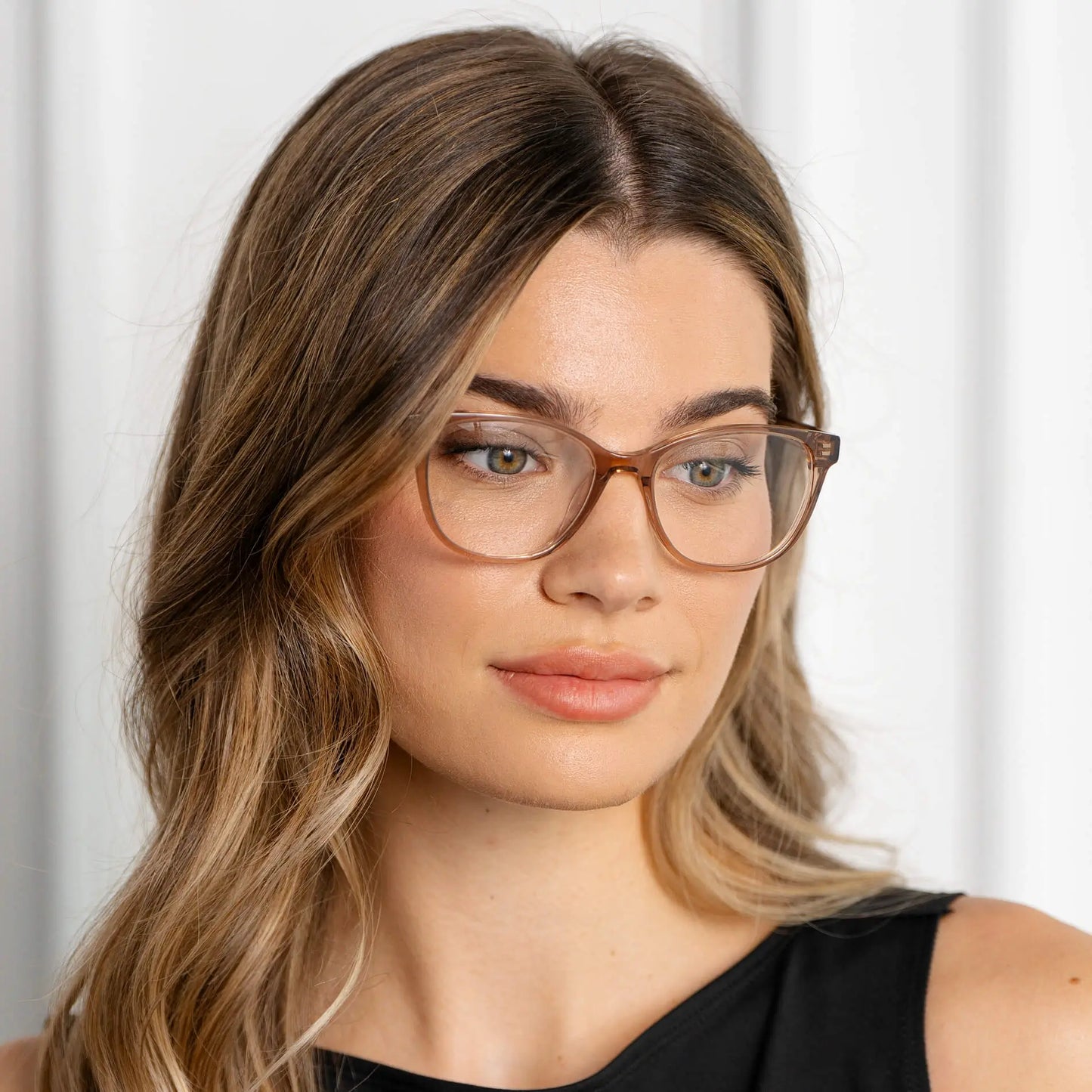 Light Brown || Mara blue light glasses with translucent warm brown rounded frames worn by woman with natural makeup