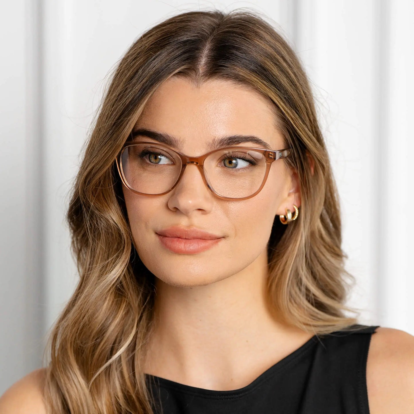 Light Brown || Mara blue light glasses with translucent warm brown rounded frames worn by woman with natural makeup