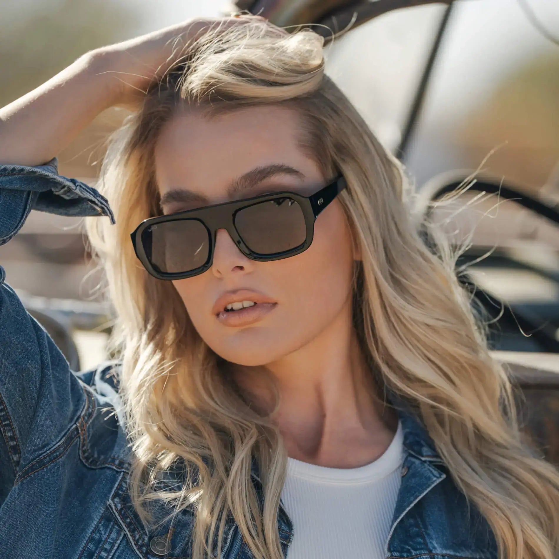 Black / Grey || Large rectangular prescription sunglasses with thick black acetate frames and a wide flat bridge worn by a woman outdoors