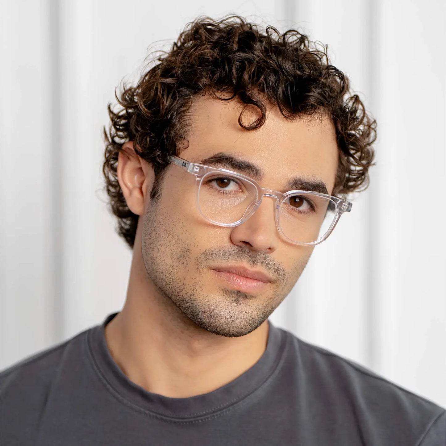 Clear || Modern square prescription eyeglasses with clear acetate frame and lenses worn by a man in natural light