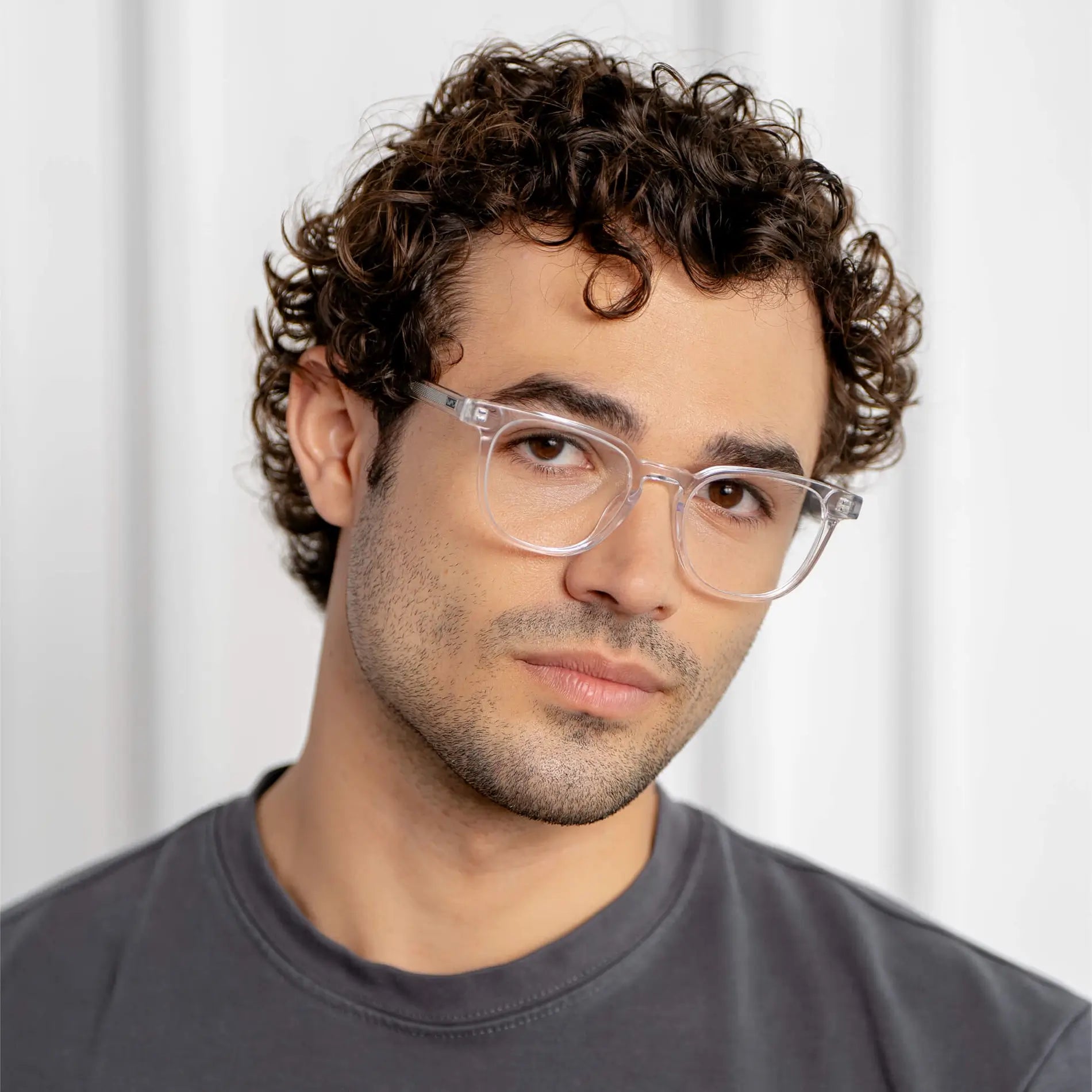Clear || Modern square prescription eyeglasses with clear acetate frame and lenses worn by a man in natural light