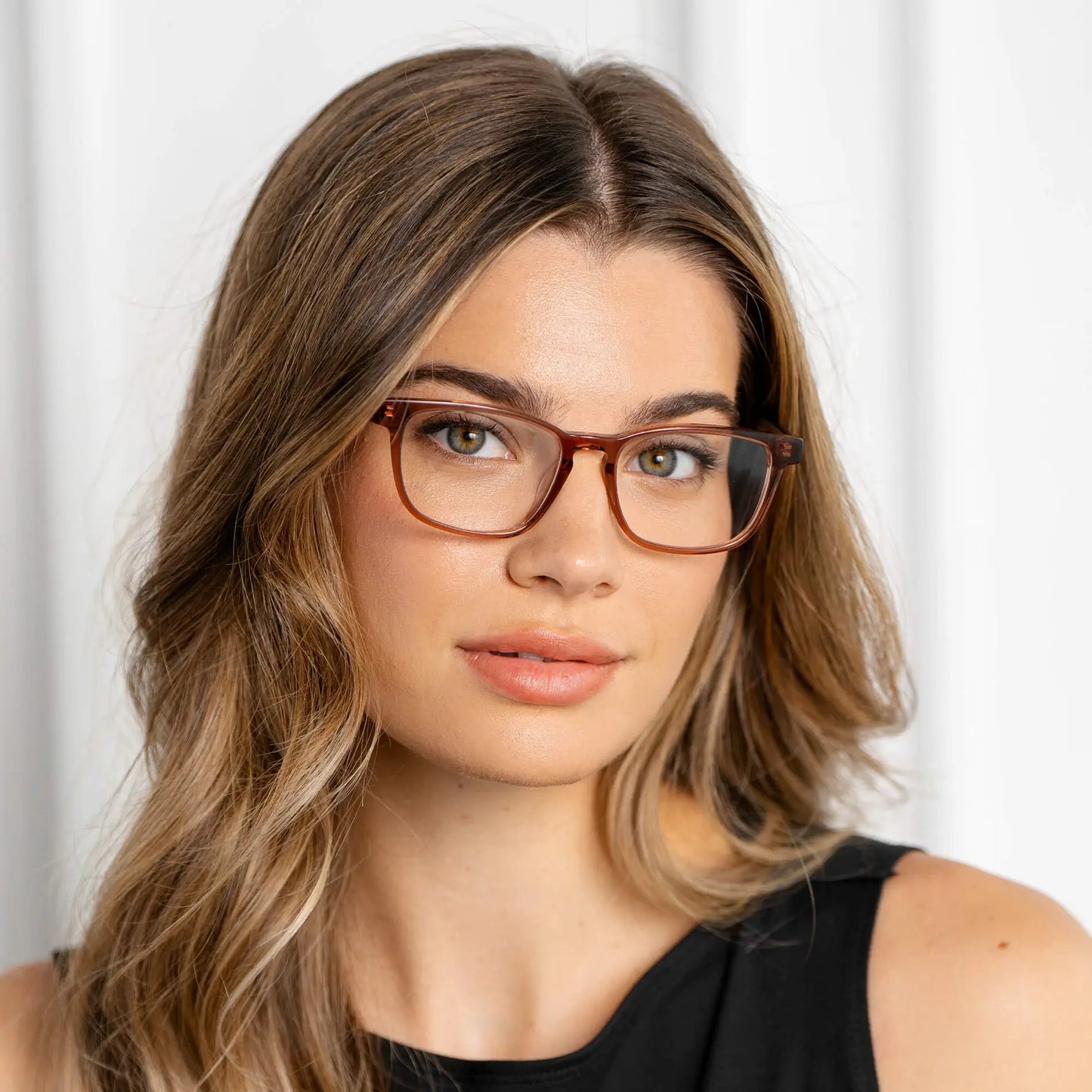 Redbrick Brown || Modern rectangular prescription eyeglasses with redbrick brown acetate frame and clear lenses worn by woman indoors in natural light