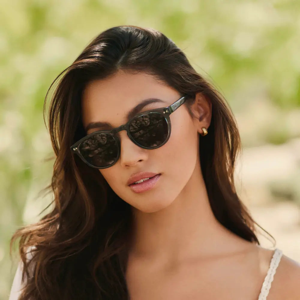 Black Case || Woman wearing black round frame sunglasses with dark lenses outdoors in natural light