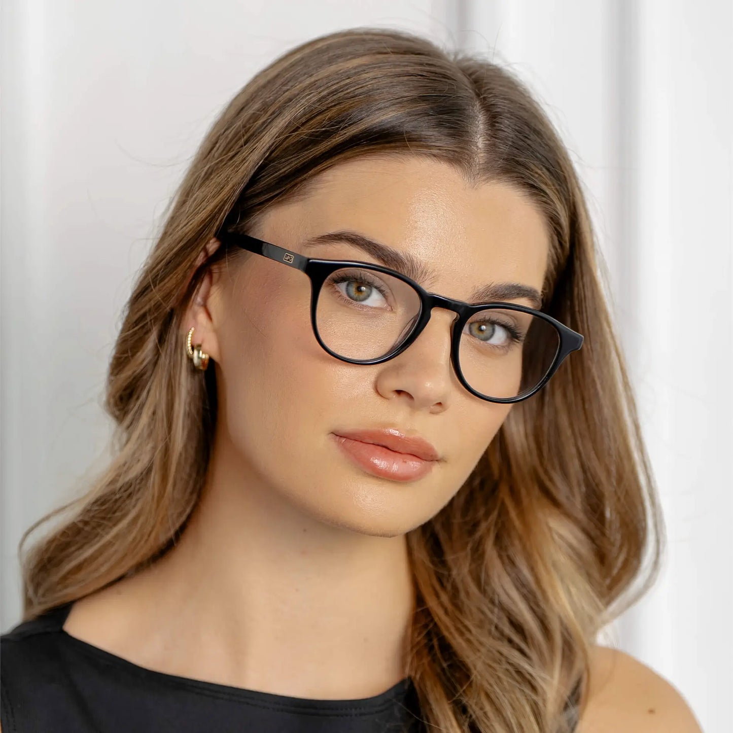 Black || Wade rounded blue light glasses with black frames worn by woman with light brown hair and gold earrings