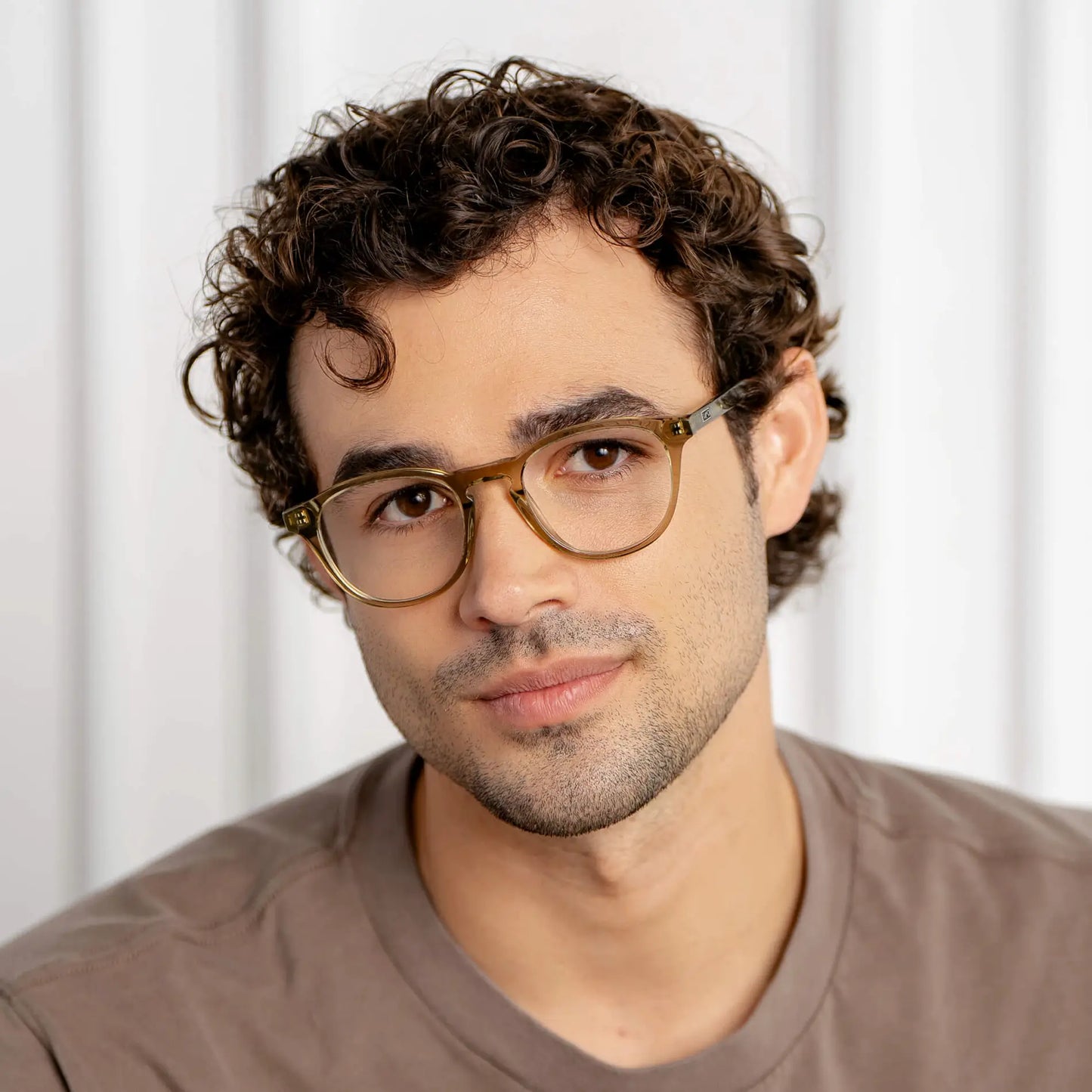 Crystal Moss Green || Wade blue light glasses with translucent moss green round frames worn by man with curly hair in natural lighting
