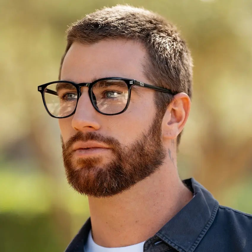 Black || Modern square prescription glasses with black acetate frame and subtle metal accents worn by man outdoors