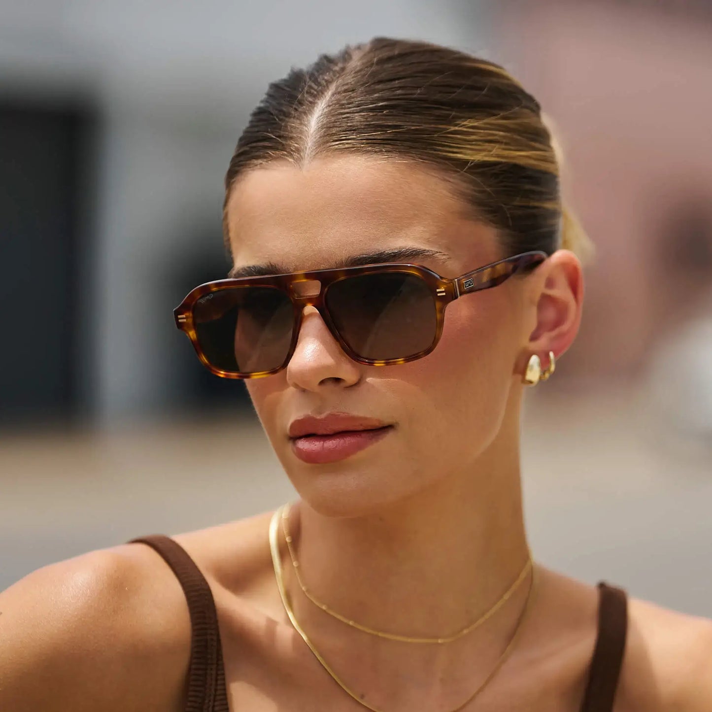 Saddlewood Tortoise / Amber || Aviator prescription sunglasses with thick acetate tortoiseshell frame and brown rectangular lenses on a woman outdoors