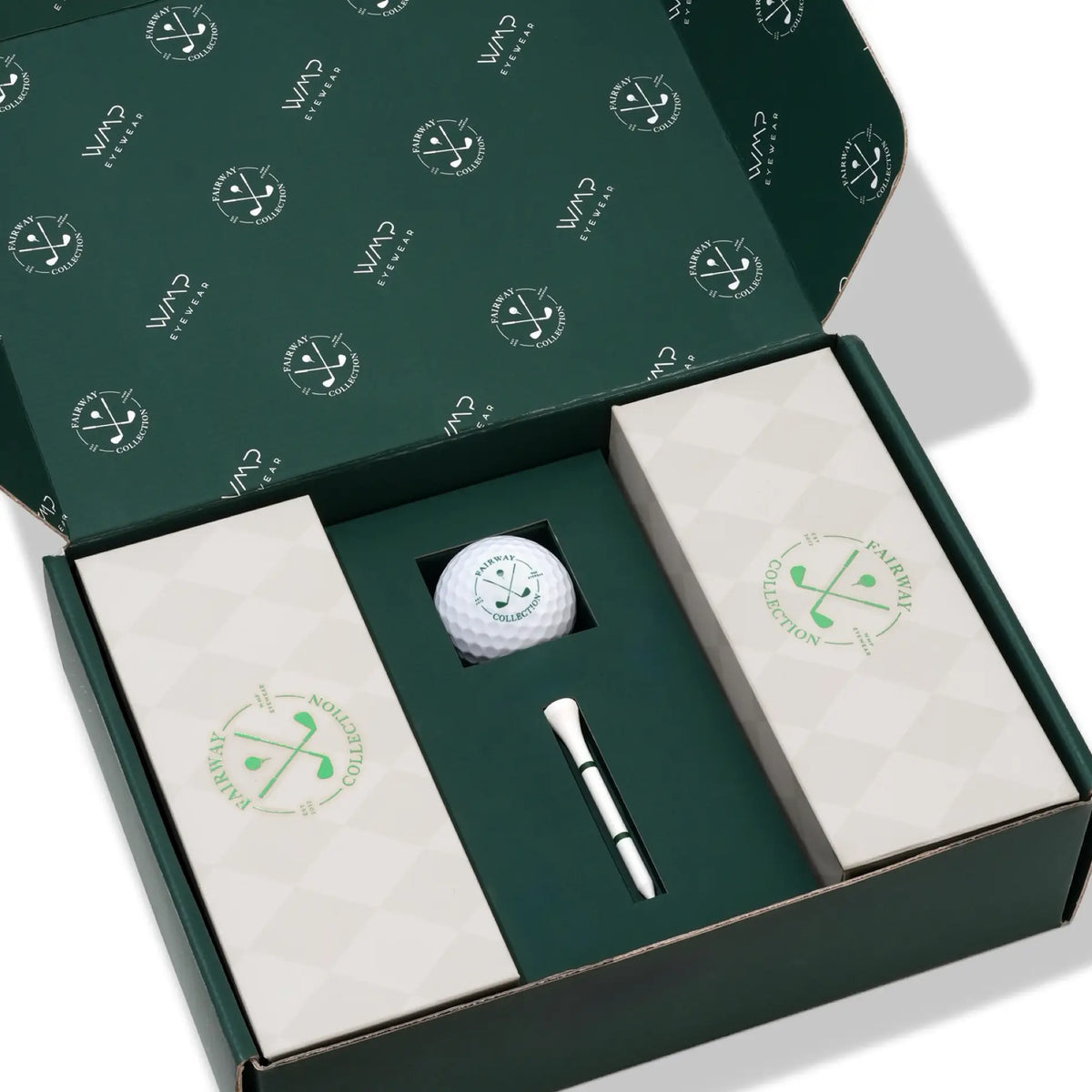 The Bunker Kit || Open green box kit with a golf ball, golf tee and two light grey rectangular boxes for sunglasses