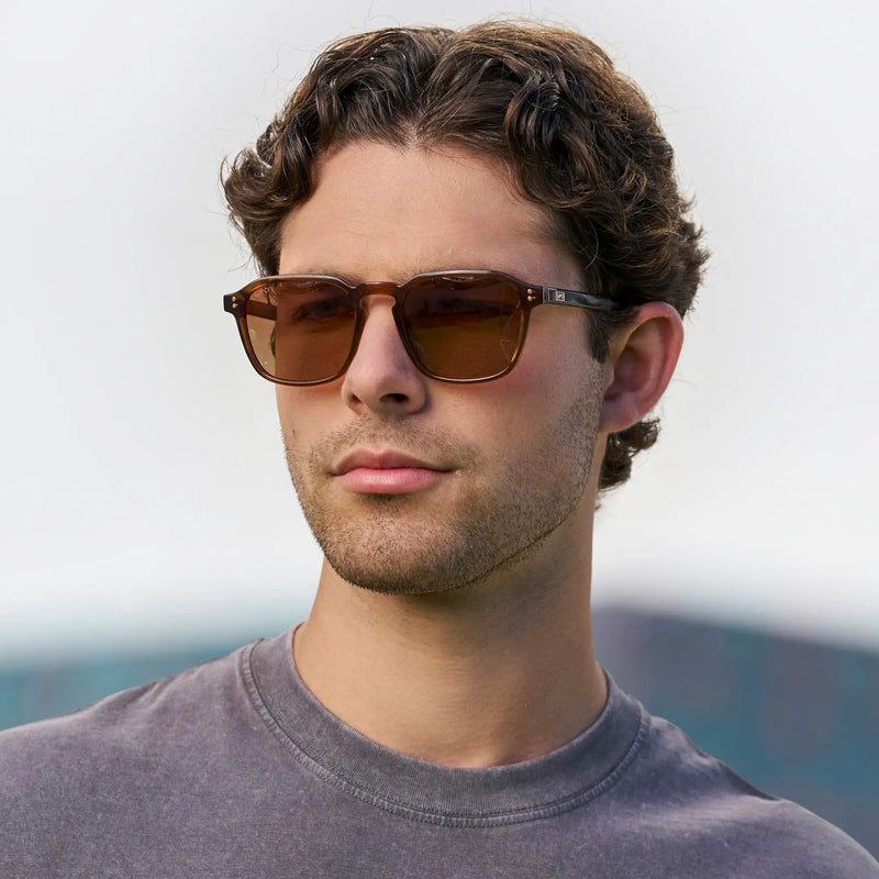 Man wearing WMP Eyewear geometric square sunglasses in terracotta brown with brown lenses and gold dot rivets