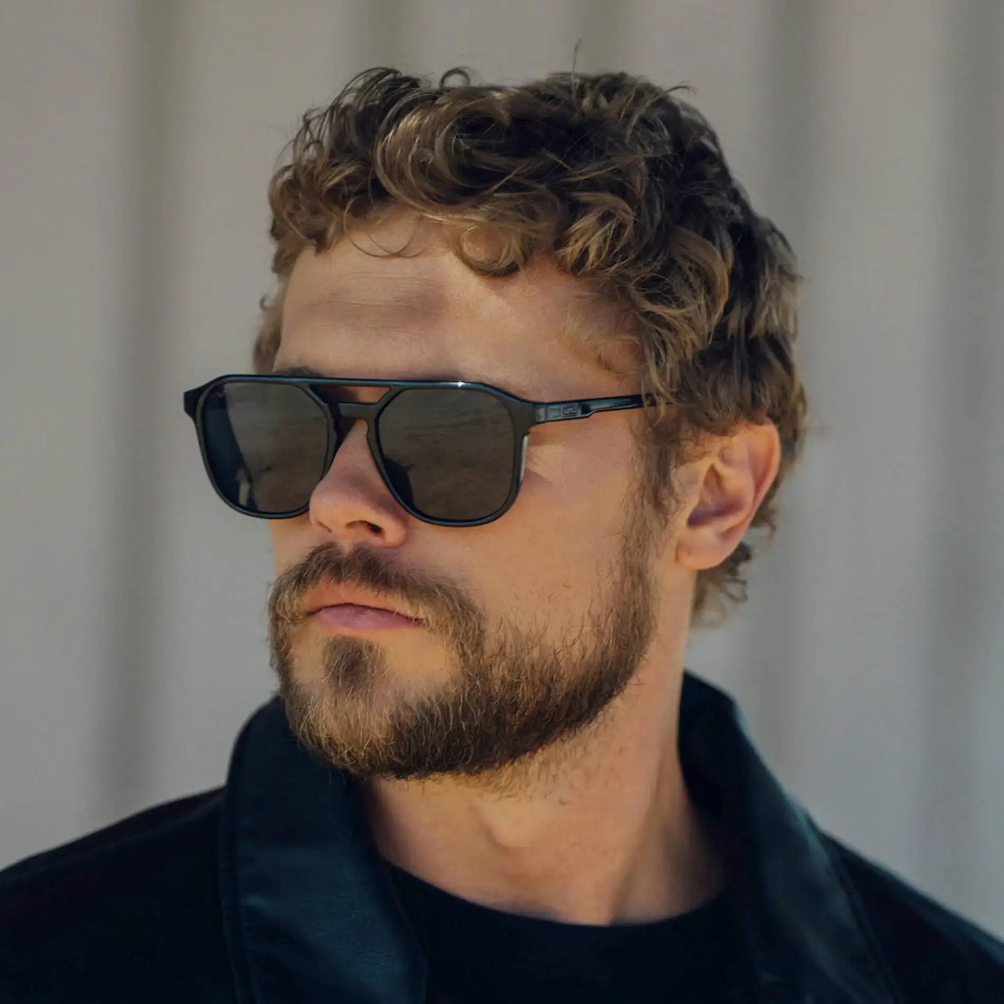 Black / Grey || Modern square sunglasses with thin black metal frame, horizontal double bridge, and grey lenses worn by man outdoors