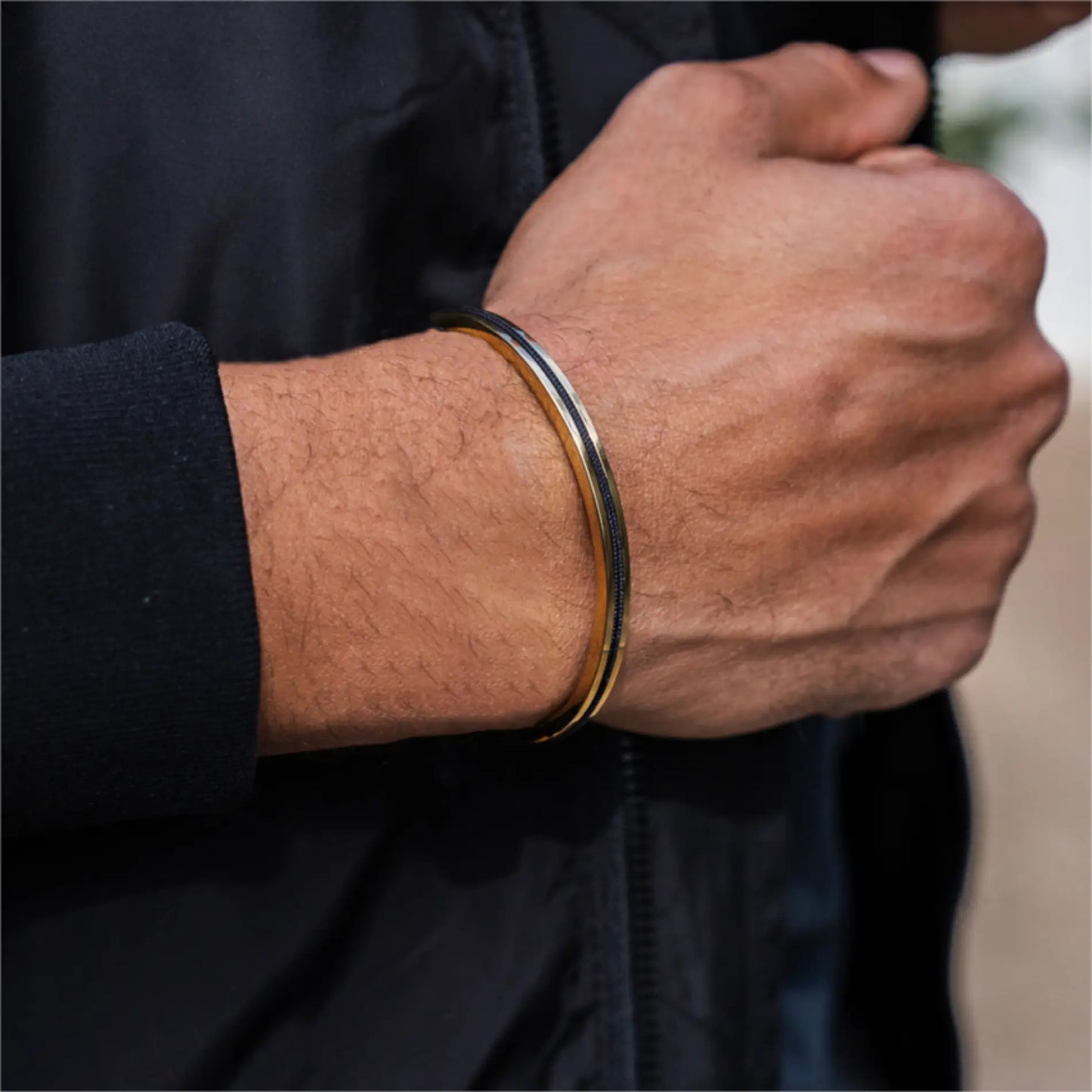 Gold / Onyx Black || Close up of a model wearing the 14K Gold Plated Adjustable Cuff Bracelet with Black Nylon Rope in natural lighting. 