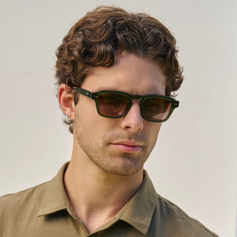 Man wearing WMP Eyewear rectangular sunglasses in dark green with gradient brown lenses