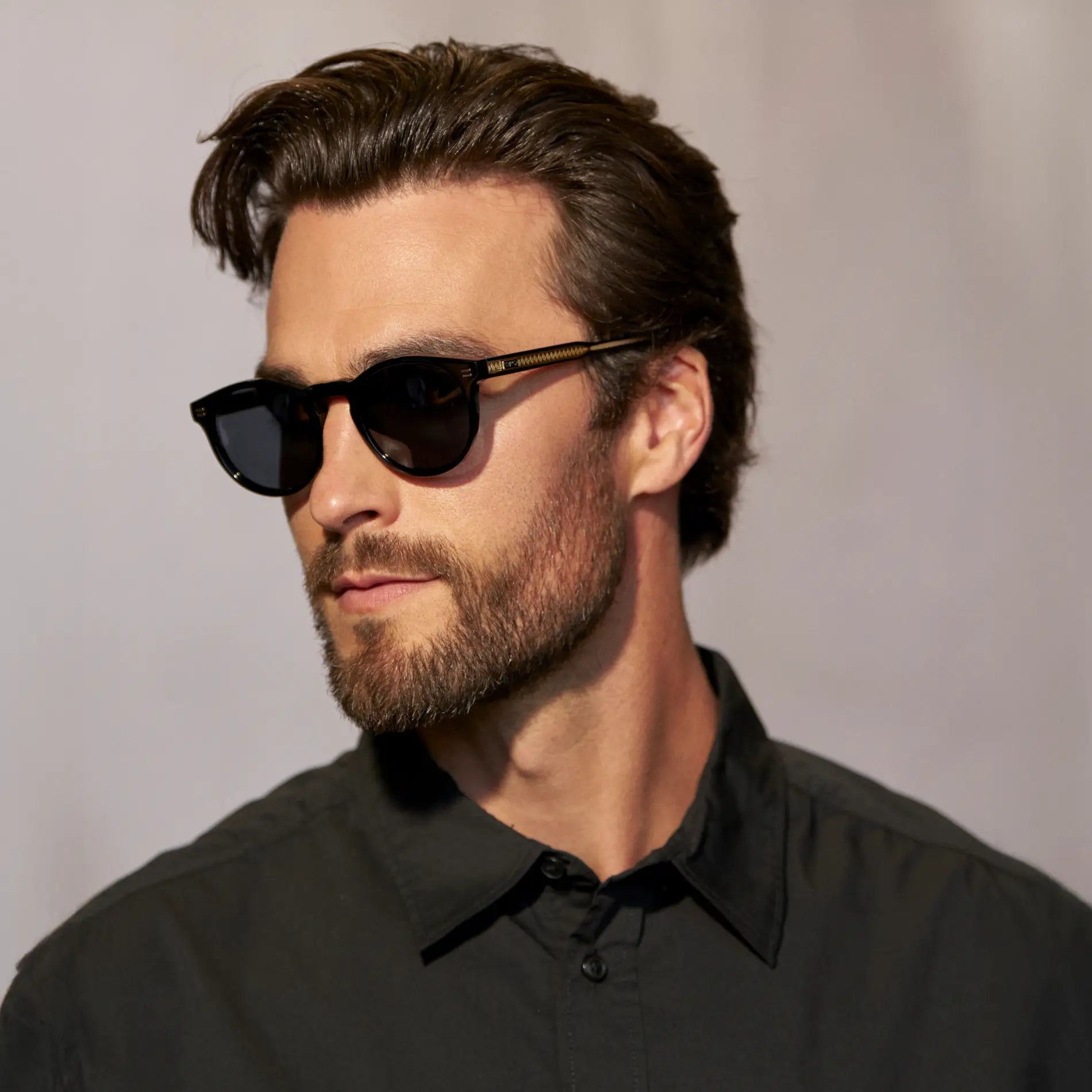 Black / Grey || Side view of model wearing Men's Round Prescription Sunglasses with Black Frame and Grey Lens