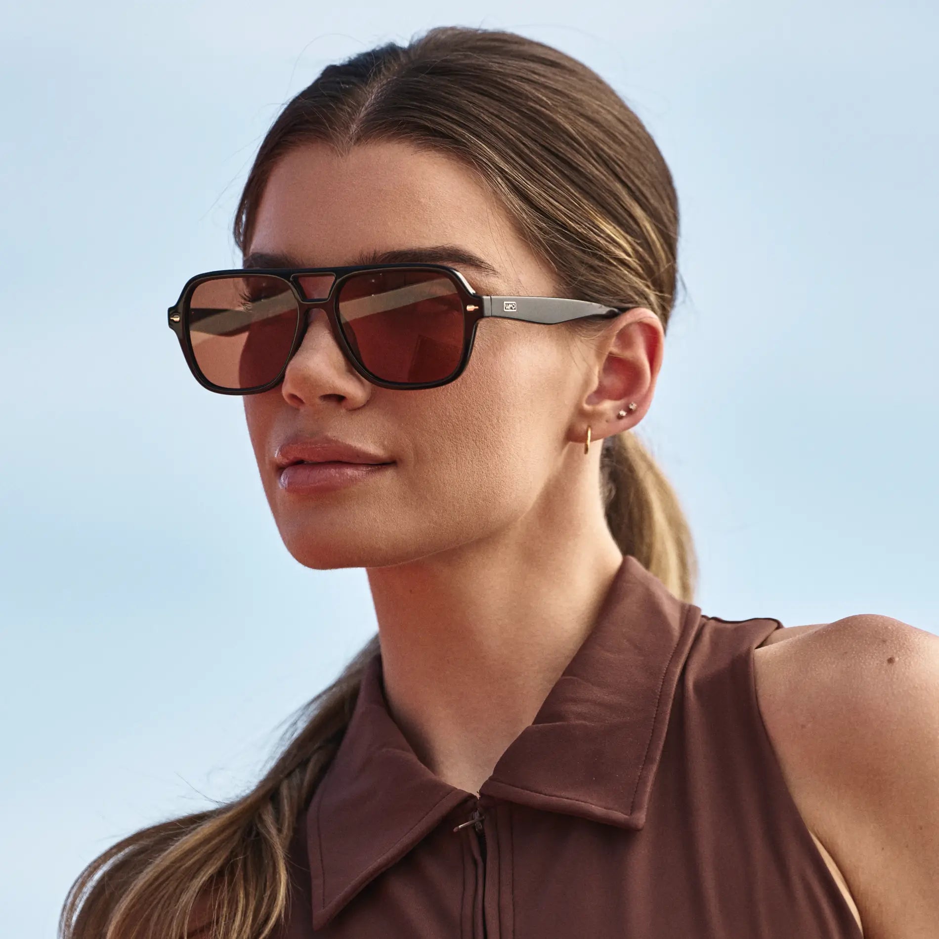 Black / Tinted Red Lens || Woman wearing Flat-Top Aviator Sunglasses with Black Frame and Tinted Red Lens in natural light