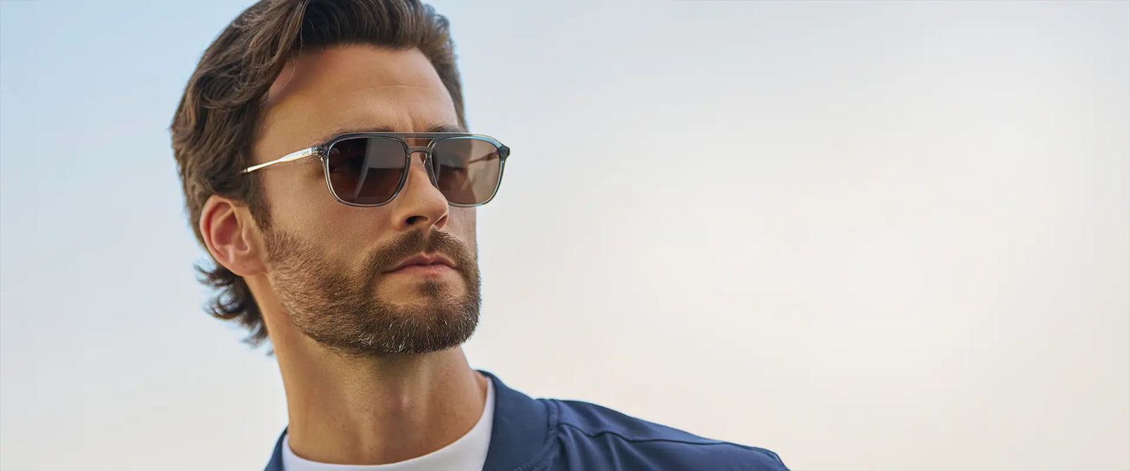 Model wearing Gage sunglasses in Stone Blue in a close-up outdoor lifestyle photo.